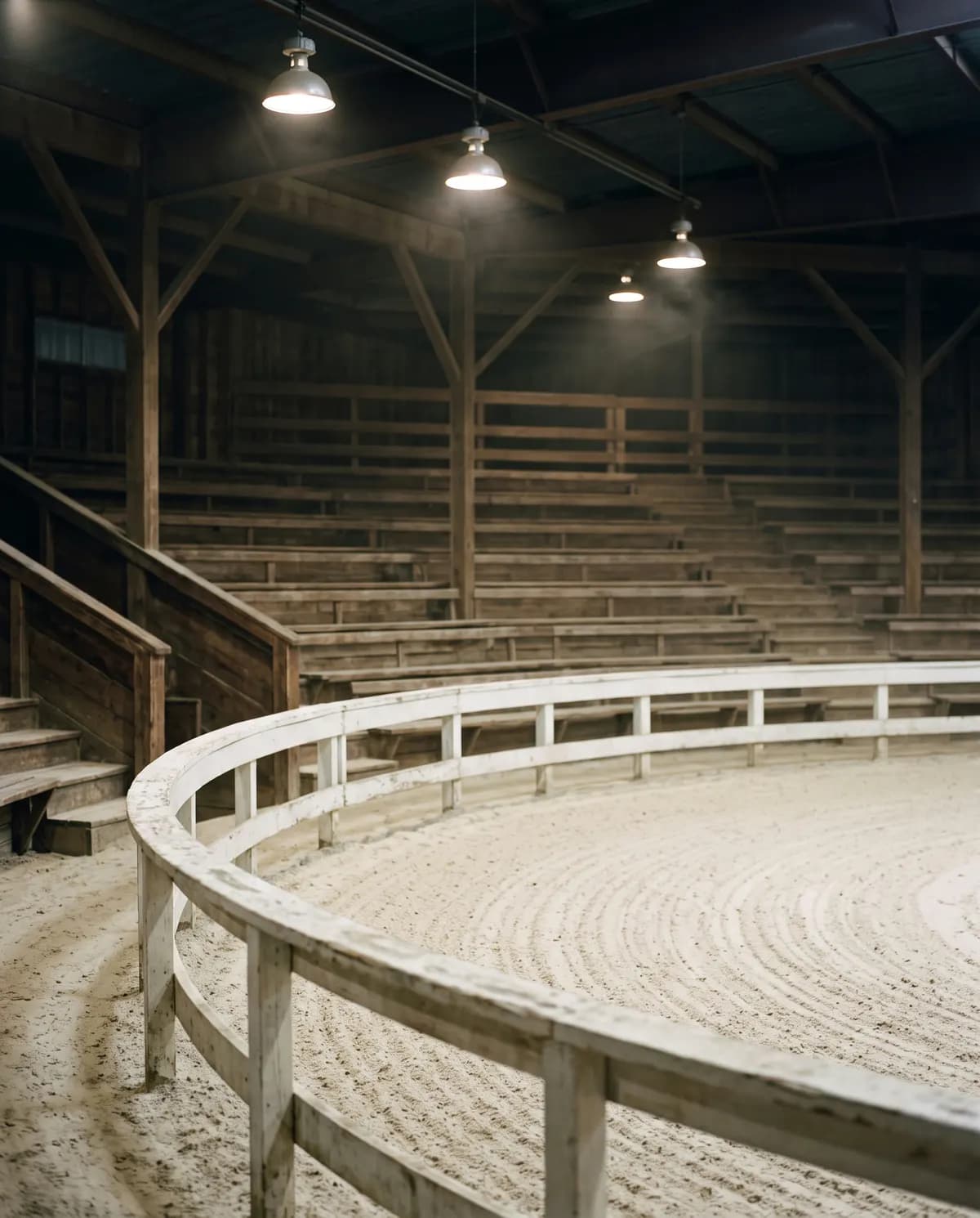 An empty sale ring, freshly raked, the lights on before a sale.